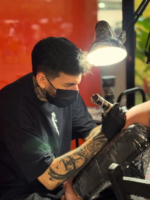 Um artista tatuando no estúdio